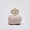 Ball of pink cashmere yarn with a Cardiff label on a light gray background